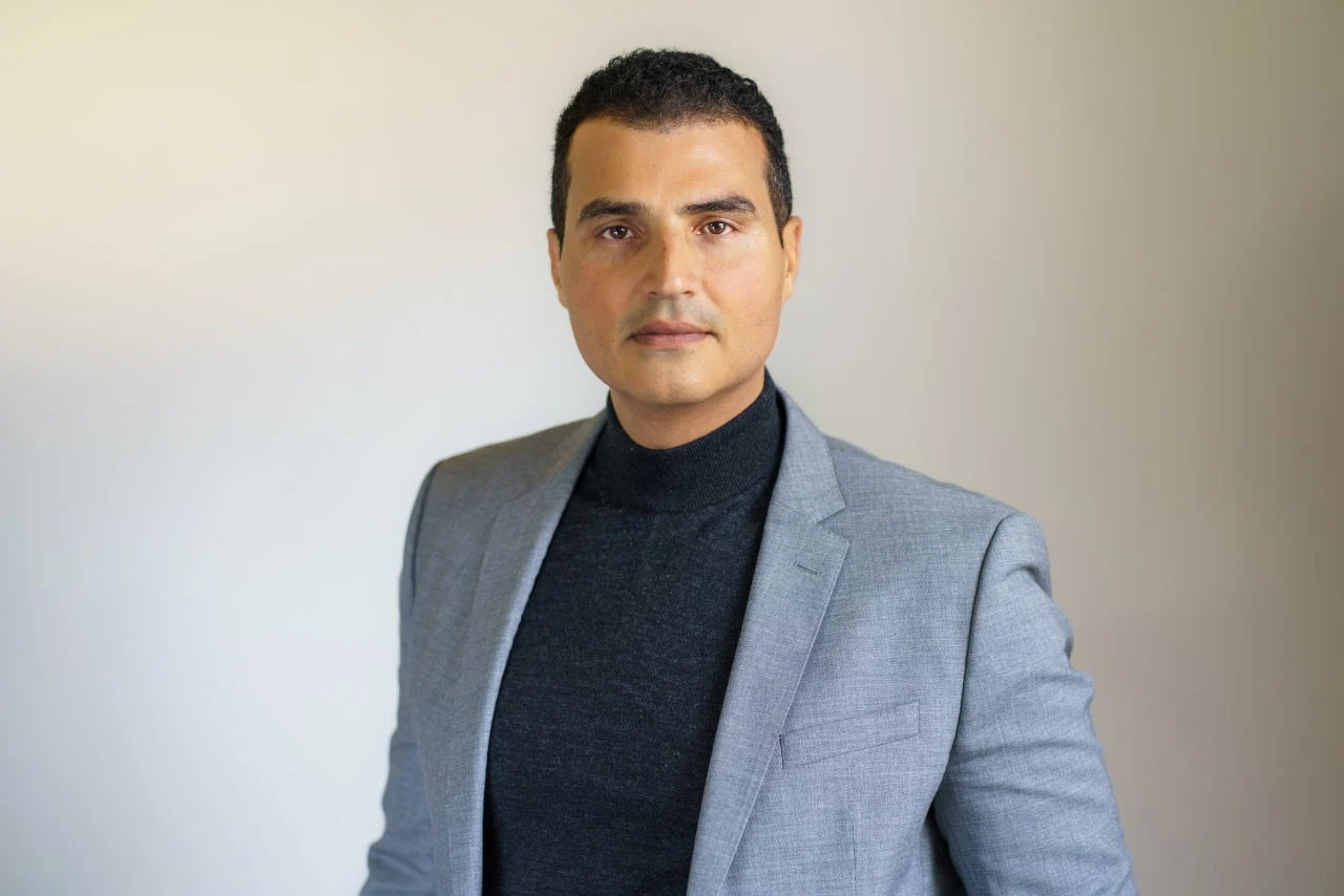 Loay Elbasyouni — grey blazer and black top. Photo: Erric Wright, July 2025.